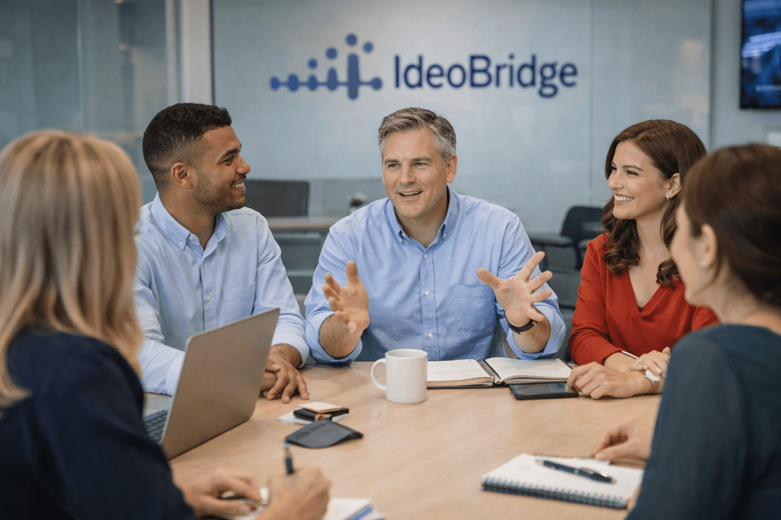 Elias at IdeoBridge conference table in animated discussion with colleagues