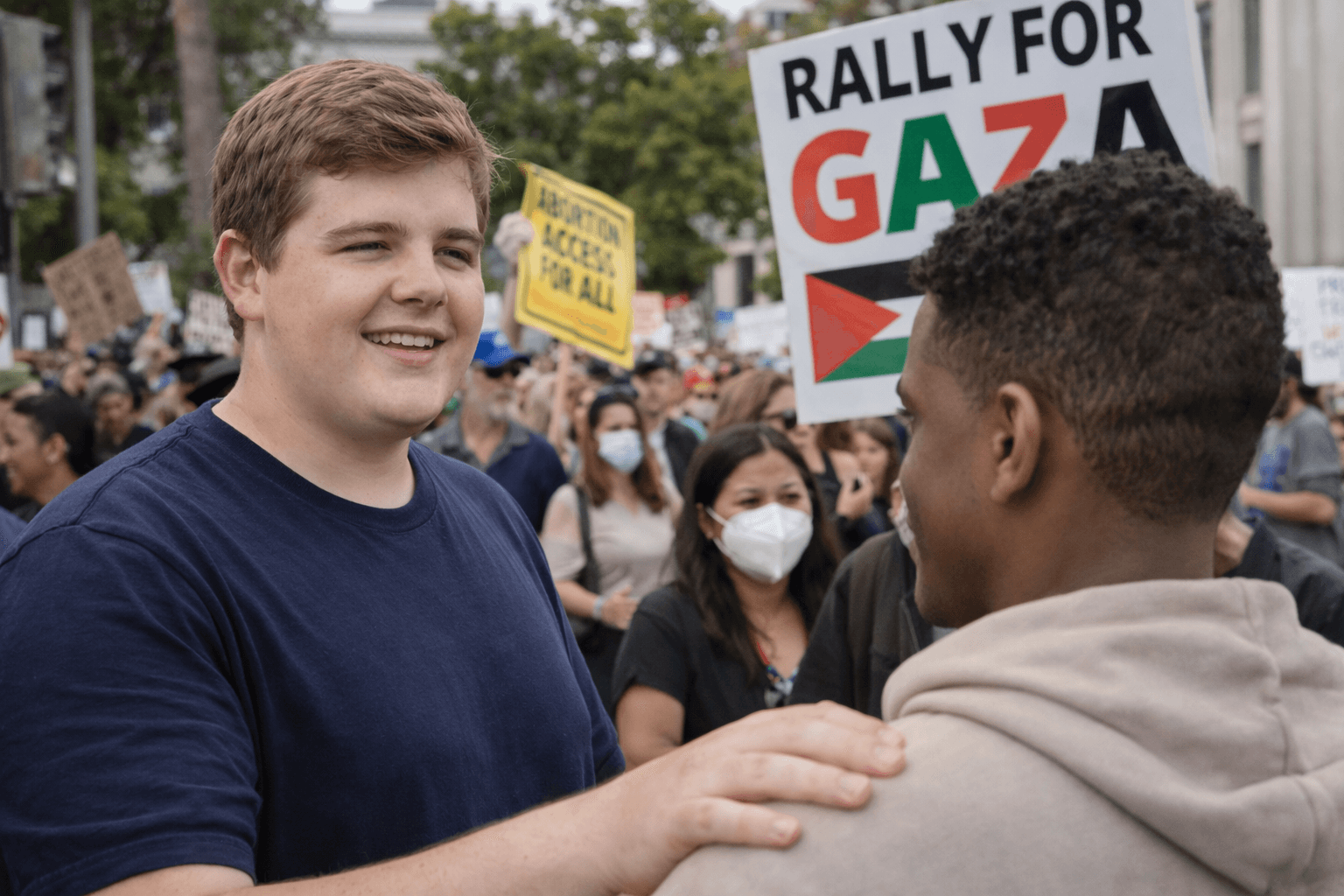 I’ve learned not to trust first impressions—but I still write them down.
Berkeley. Late afternoon. The kind of daylight that makes everything look honest even when it isn’t. John Hawthorne was easy to spot once you knew what to look for: standing left of center, relaxed posture, half-smile that didn’t quite match the noise around him. He didn’t look like a protester chasing a cause. He looked like a guy listening.
That mattered.
The crowd was loud—signs up, voices bouncing off old stone buildings. Gaza. Abortion access. A dozen overlapping reasons to be angry, hopeful, or both. John wasn’t holding a sign. That’s always a tell. People without signs are either lost… or paying attention.
He was talking to someone younger, close, hand on the shoulder. Not aggressive. Familiar. The kind of contact meant to steady a conversation, not dominate it. Around them, faces blurred together—masks, phones, slogans—but John stayed anchored, calm in the middle of the churn.
Sources later told me this was where lines crossed. Not officially. Not on paper. Just people who weren’t supposed to overlap, suddenly doing exactly that. No speeches. No chanting. Just proximity and timing.
If this was a coincidence, it was a useful one.
John Hawthorne didn’t look like a man making a statement. He looked like a man being seen—by the wrong people, at the right moment. And in my line of work, that’s usually where the story starts getting interesting.